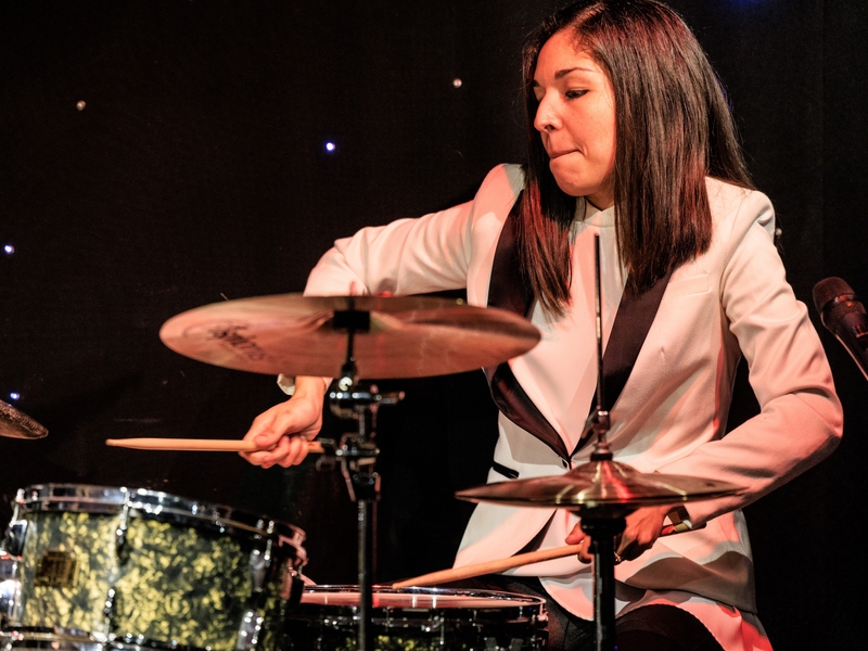 Colour photo of Migdalia Van Der Hoven playing the drum kit