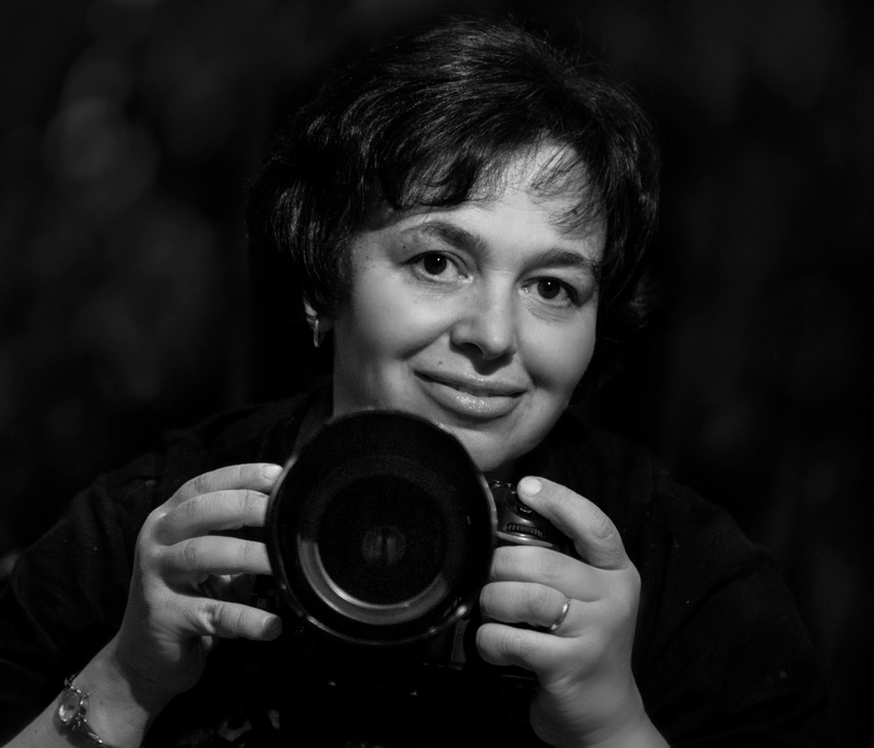 Black and White selfie of photographer Tatiana Gorilovsky holding camera, ready to shoot.